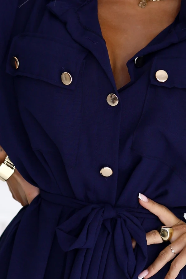 Modelka w granatowej szmizjerce z paskiem i złotymi guzikami – elegancka sukienka koszulowa marki Numoco Basic, idealna na co dzień i do pracy.