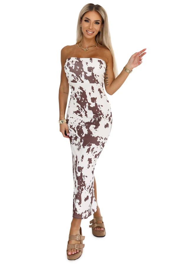 Modelka prezentuje dopasowaną sukienkę Savannah bez ramiączek w brązowo-biały wzór boho. Sukienka o długości midi podkreśla sylwetkę i idealnie sprawdza się na lato, wakacje lub wieczorne wyjście.